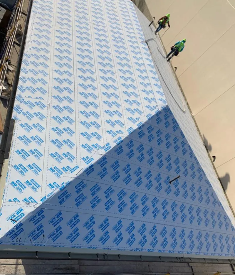 Professional roofers installing underlayment on a metal roof in Canton